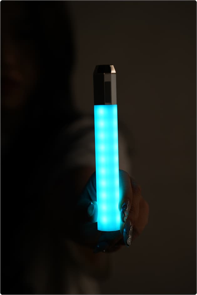 A Litsaber glowing cyan, held out toward the camera in a dark room